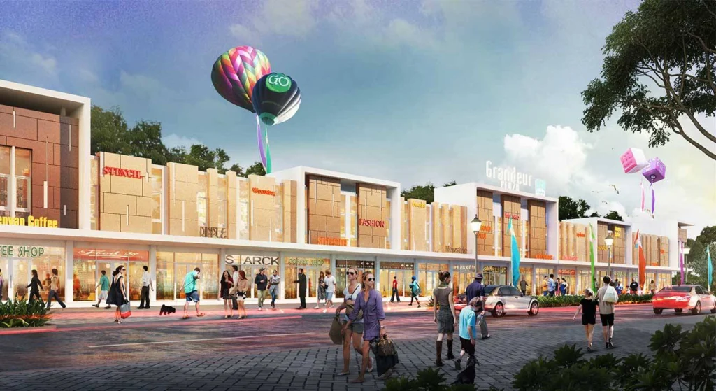 Tampilan depan ruko Grandeur Plaza di CitraLand Cirebon. Bangunan komersial modern dengan dua lantai, keramaian pengunjung, dan area pejalan kaki yang ramai, menunjukkan suasana bisnis yang hidup.
